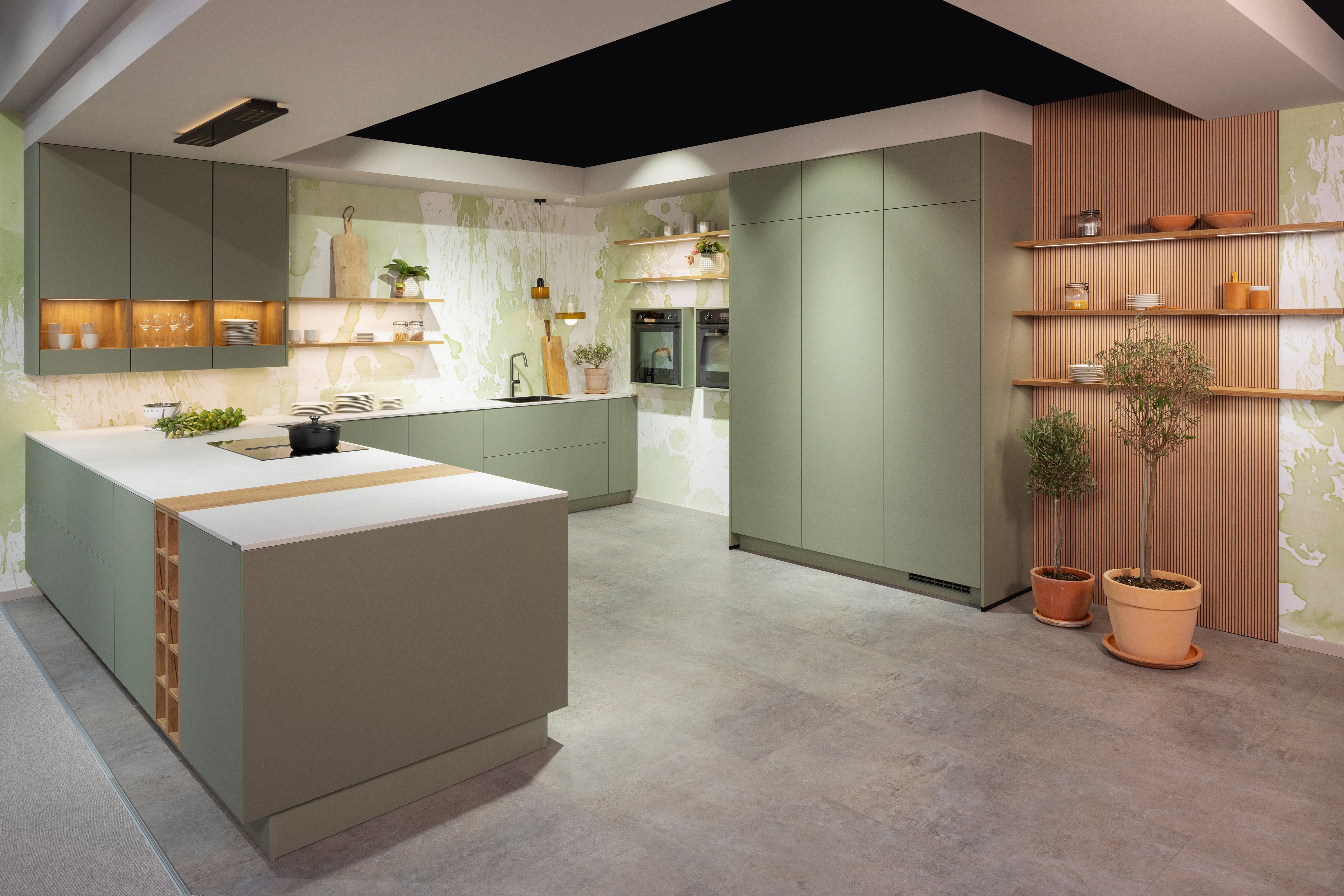 APL: 794 Beton Seidengrau NB (Xtra Ceramic) Korpus: 198 Eiche Sierra Front: Senso 495 Lack, Olive Premium matt Geräte: Neff Slide&Hide Armatur: Gessi  Spüle: Teka  Features: Trendfarbe Olive, Push to open, Tapete, neuer Schubkasten, Wandeinbau Backofen, beleuchtete Regale, beleuchtete Vitrinen, Weinflaschenregal, Schubkästen und Korpus in Eiche Sierra, Premium matte Oberfläche mit Antifingerprint, Nischenrückwand in Rillenoptik.